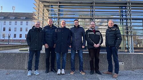 The group of experts on the campus of the University of Wismar in front of the library building.
